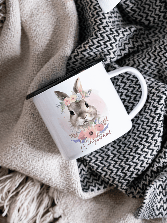 handgemachter, personalisierter Emaillebecher mit schwarzem Rand und Motiv Hase als Geschenk für Frauen. Motiv ist links vom Henkel aufgedruckt