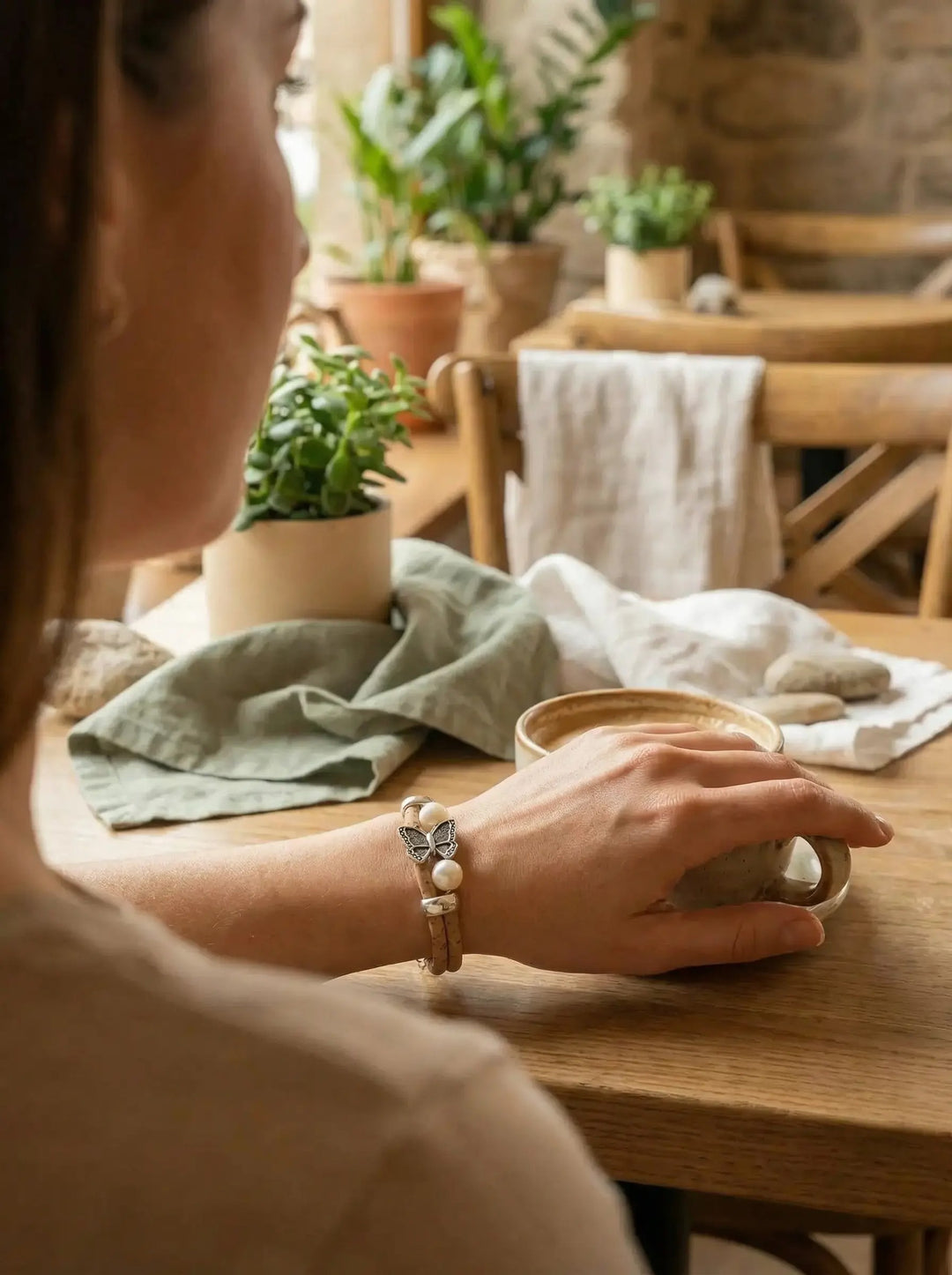 Korkarmband mit feinem Schmetterlingsmotiv von Frau an linken Arm getragen – Achtsame Geschenke für Frauen bei Alles auf Anfang in Bedburg, NRW