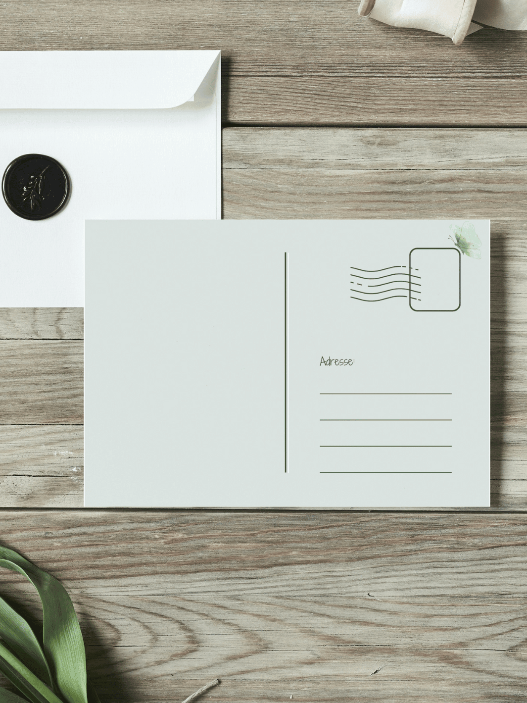 Eine Postkarte mit der Rückseite nach oben liegt auf einem Holztisch.  Achtsame Geschenke für Frauen. Alles auf Anfang